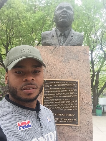 The author standing next to Dr. King's bust in East Harlem